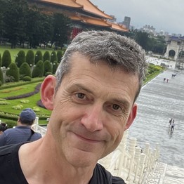 Ein Mann mit grauem, kurzem Haar lächelt in die Kamera.